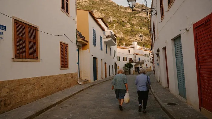 Elderly couple walking in a Mediterranean village